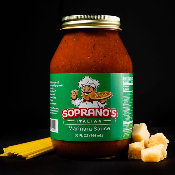 Soprano's Italian Marinara Sauce jar with spaghetti and parmesan cheese on a black background.