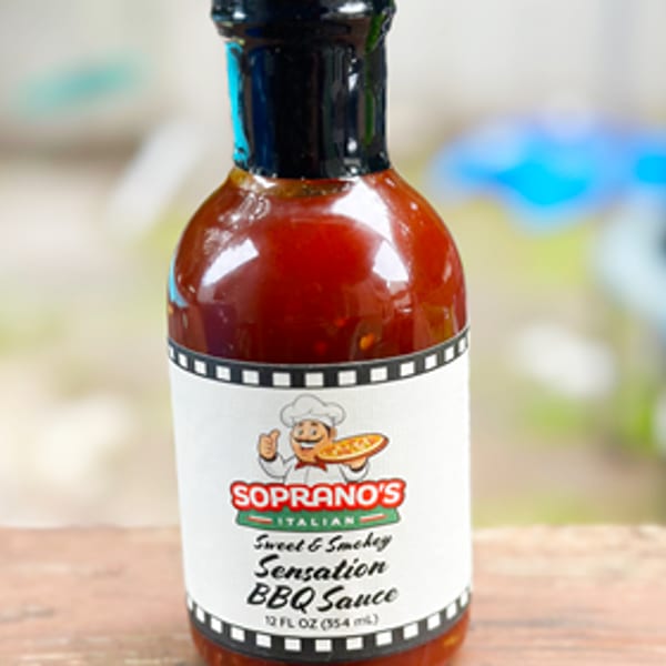 Soprano's Italian Sweet & Smokey Sensation BBQ Sauce in a clear glass bottle.